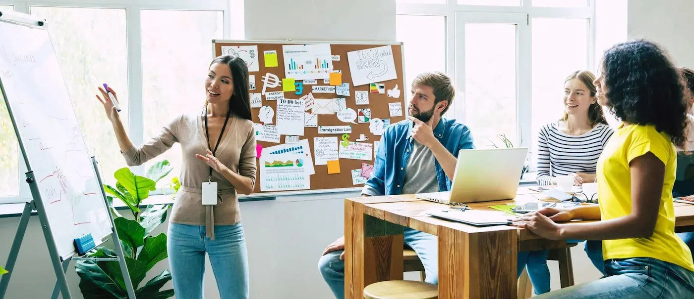 a lady in an office pointing to a Bestboard mobile whiteboard
