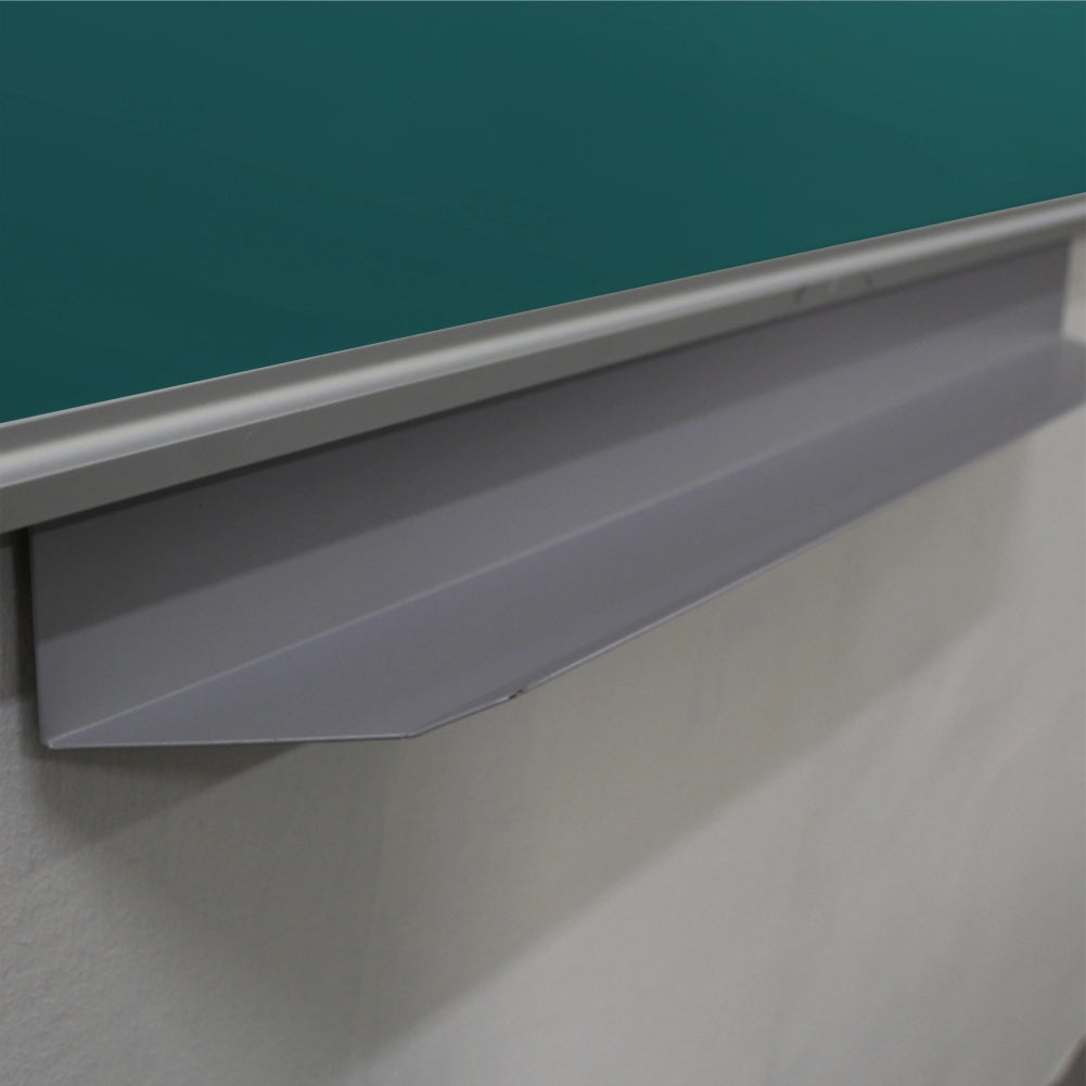 Close-up of a gray metal chalkboard lip or penrail mounted beneath a green chalkboard on a white wall.