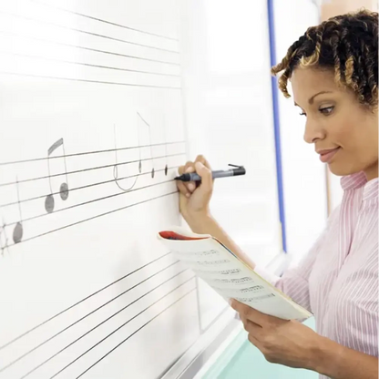 Person writing on a whiteboard with musical notation
