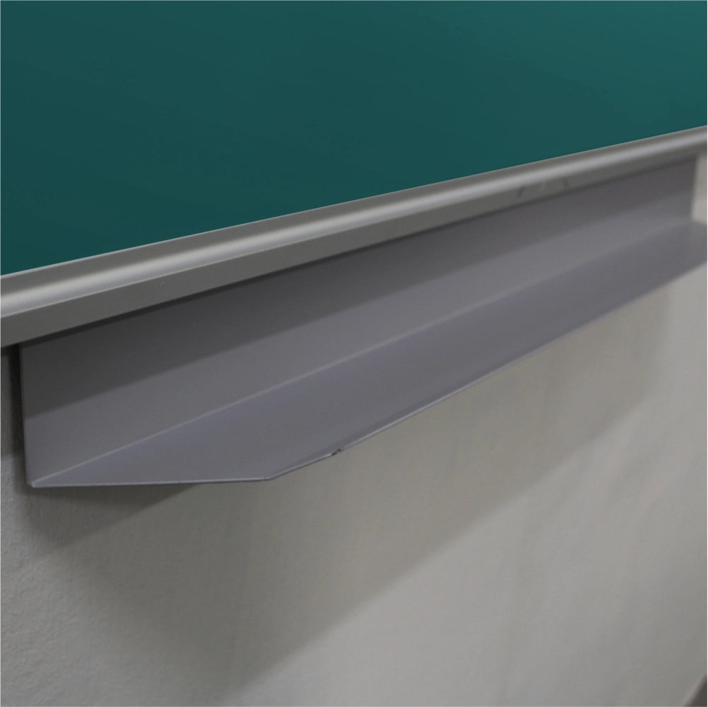 Close-up of a gray metal chalkboard lip or penrail mounted beneath a green chalkboard on a white wall.